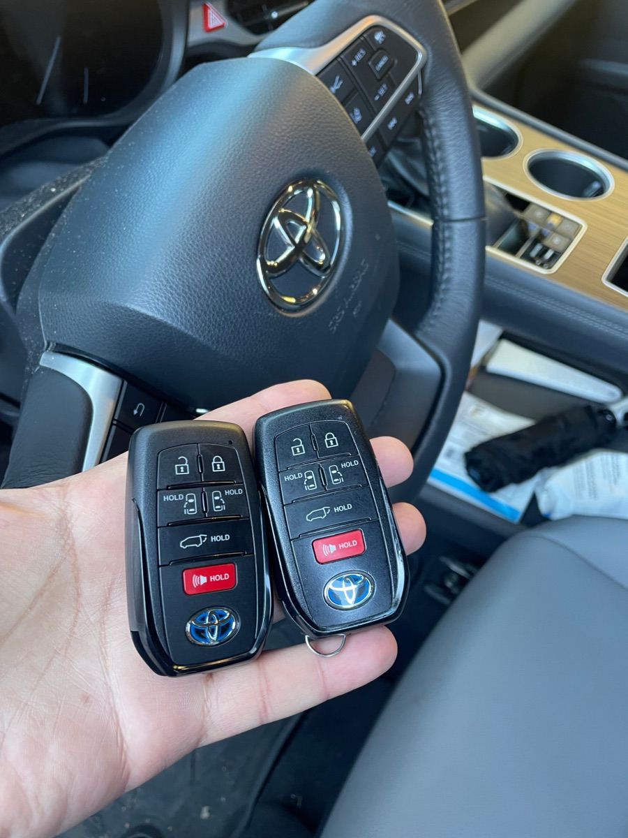 Two Toyota smart keys held in front of the steering wheel on a 615 Locksmith job