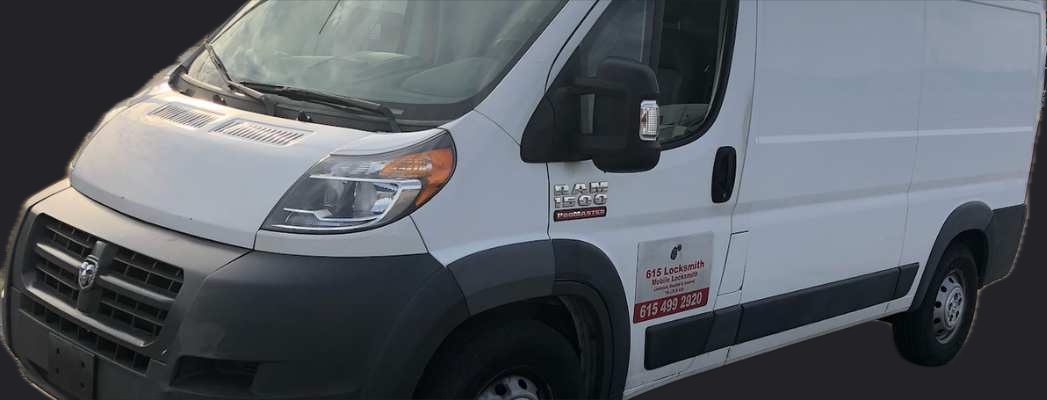 The white 615 Locksmith van, with the company name and phone number on the door